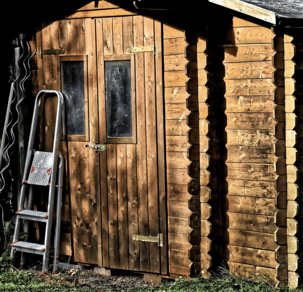 Geräteschuppen aus Holz mit Gartenutensilien